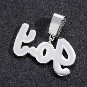 Gros plan d'un pendentif hip-hop en argent poli avec une surface brillante et un bélière