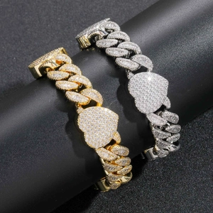 Détail macro de bracelets à maillons cubains avec grands pendentifs en cœur or et argent