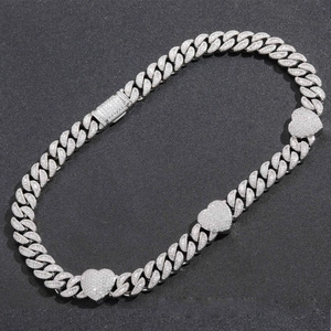 Gros plan d'un collier cubain en argent glacé avec trois cœurs sertis de zircons