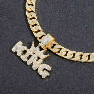 Macro view of gold plated Cuban chain and KING letter pendant with iced out pavé zircons