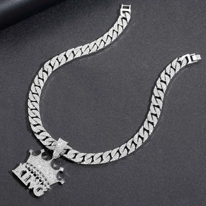 Dettaglio del ciondolo a corona KING in argento e catena cubana con strass lucidi