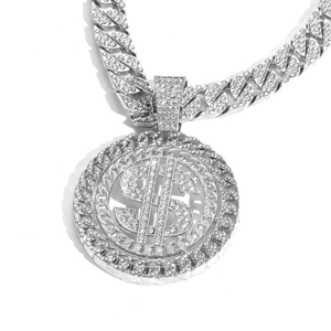 Macro shot of iced-out silver dollar sign pendant with sparkling rhinestones on Cuban link chain