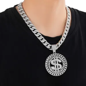 Detail showing an iced out dollar sign pendant on a silver Cuban link chain for men