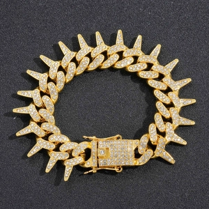 Gros plan du bracelet Cuban à pointes serti de zircons brillants sur fond gris texturé