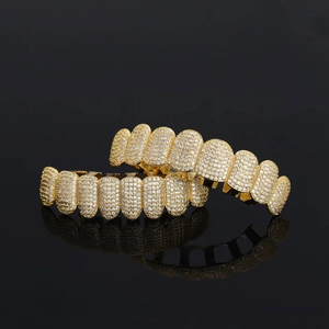 Hip hop gold grillz set with micro-paved cubic zirconia on glossy black reflective background