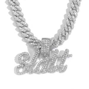 Détail du pendentif Slatt serti de strass et de la chaîne à maillons cubains argentée