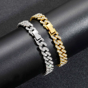 Close-up of gold and silver Cuban link bracelets with sparkling white rhinestones