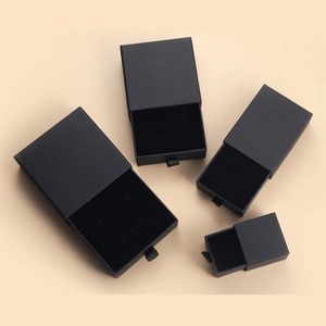Set de cuatro cajas de joyería negras mate con tiradores de cinta en fondo beige