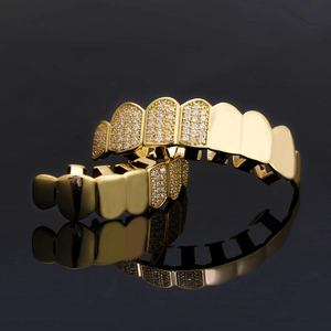 Grillz hip hop dorati con micro pavé di zirconi su superficie a specchio nera