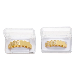 Dettaglio di grillz hip hop dorati con zirconi micro-incastonati e custodie in plastica