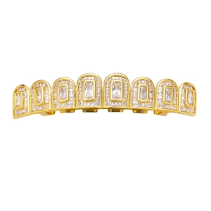 Macro shot of hip hop grillz featuring baguette cut cubic zirconia on gold plated metal