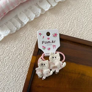 Detalle de coletero de gato bordado rosa con vestido de lentejuelas en tarjeta floral