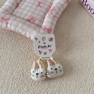 Detail van de pluchen konijnen haarelastiekjes met roze wangen en gele elastiekjes