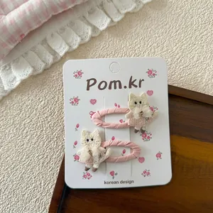 Detalle de dulces horquillas de gato bordado rosa con encaje en tarjeta decorativa