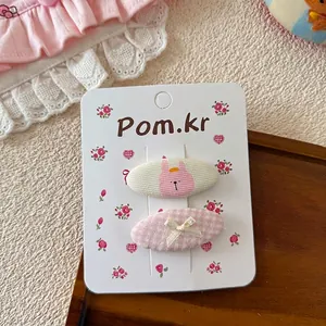 Gros plan sur les barrettes roses en tissu avec motif lapin et nœud sur carton