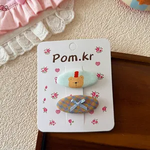Détail de pinces à cheveux style coréen pour enfants avec ours et nœud à carreaux