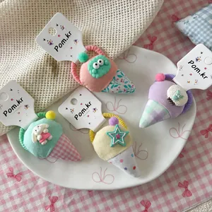 Pastelkleurige stoffen haarelastiekjes met schattige 3D-dierbedeltjes op wit keramiek bord