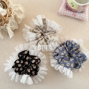 Detailed view of floral scrunchies set with delicate lace trim on textured background
