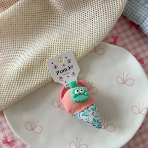 Detail van macaron roze ijsje haar elastiek met munt pompon en schattige oogdecoratie