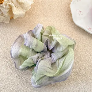 Detail of floral gradient organza scrunchie with soft pastel green and purple tones
