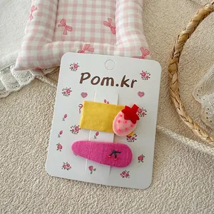Détail de barrettes à fleurs douces avec broderies fraise et cerise sur carte