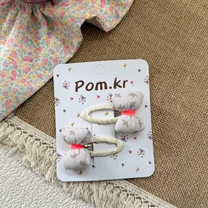 Close-up of floral bow hair clips for girls on a Korean design decorative card display