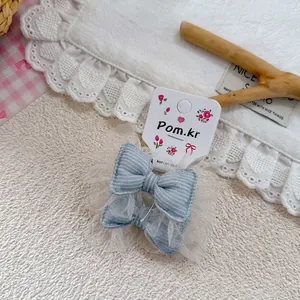 Détail d'un chouchou en denim bleu avec dentelle blanche sur carte d'exposition