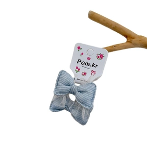Nœud pour cheveux à rayures bleues avec dentelle sur décor de branche de bois