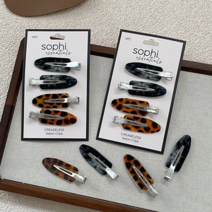 Set of four stylish leopard and marble print creaseless salon hair clips on a card