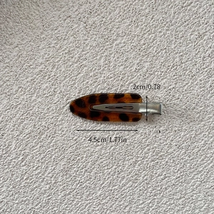 Macro detail of leopard print hair clip showing 4.5cm length and acetate texture