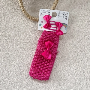 Détail d'un bandeau en crochet rose avec des barrettes à nœuds sur support de vente