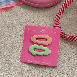 Detail of candy color wave hair clips set in light orange and green on decorative card