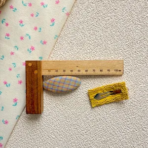 Détail des barrettes en tissu à carreaux et dentelle jaune montrant les mesures précises