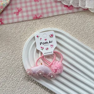 Detail of pink lace floral hair ties with pearls on a decorative ceramic tray