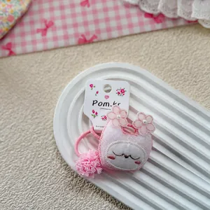 Detail of pink bunny hair scrunchies with lace floral accents on a display card