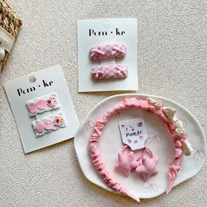 Pink plaid children hair accessories set with bows, headband and clips on white background
