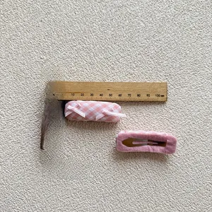 Detail view of pink plaid hair clips with bow decoration and 5cm measurement scale