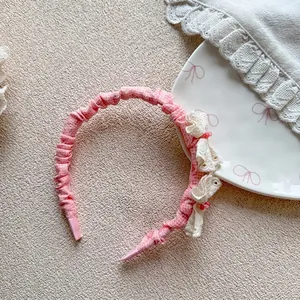 Detail of pink plaid hairband with ruffled white lace and elegant bead embellishments