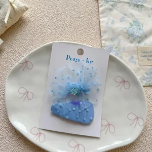 Detail of light blue mesh dot hair clip for girls on elegant ceramic display plate
