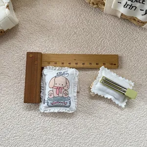 Détail de barrettes en tissu pour enfants avec motif chien et pince crocodile en métal