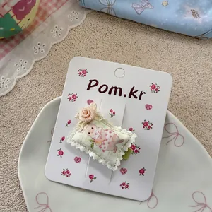 Détail de la pince à cheveux en tissu avec lapin mignon et rose sur une carte fleurie