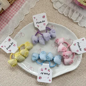 Set of pastel bow hair ties with floral embroidery and pearls on a decorative plate