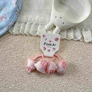 Detail of pink bow hair ties with delicate embroidery and pearls for toddler girls