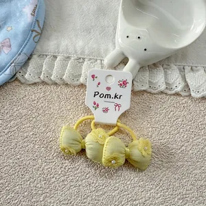 Detail of yellow bow hair ties featuring delicate pearl flower embroidery for girls
