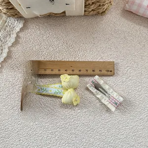 Detail of sweet floral embroidered bow hair clip and pink lace clip with ruler measurement