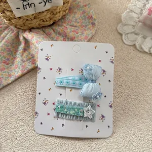 Detail of blue bow hair clips with pearls and sequin stars on a display card