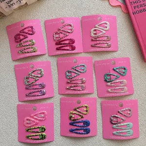 Nine sets of colorful glitter heart and teardrop hair clips for girls on pink cards