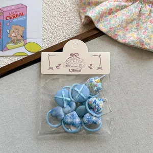 Lot d'élastiques à cheveux en tissu bleu avec motifs cœur et pois sous emballage
