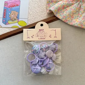Détail de l'ensemble de chouchous violets avec motifs de cœurs et d'étoiles en coffret