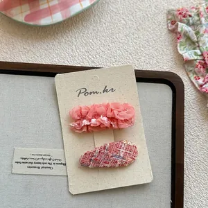 Détail d'un lot de barrettes à fleurs avec maille rose et motifs en tweed à paillettes